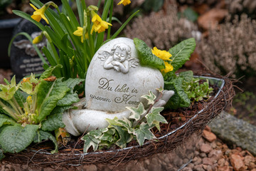 Engel mit Spruch auf einem Herz mit Blumen © Blende8