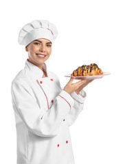 Young female confectioner with tasty croissants on white background