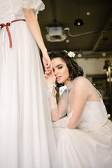 Naklejka premium Girls in white wedding dresses are posing. Advertising of wedding dresses