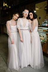 Naklejka premium Girls in white wedding dresses are posing. Advertising of wedding dresses