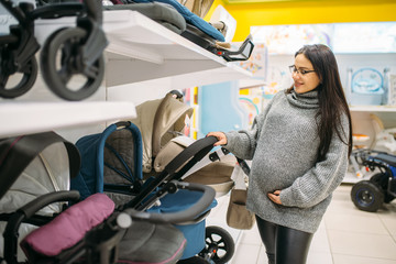 Pregnant woman in shop of goods for newborns