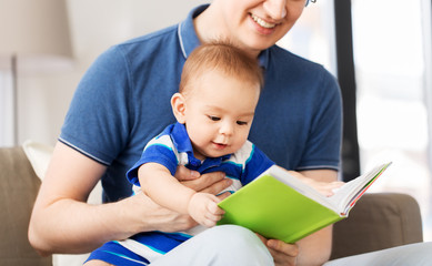 mixed-race family, parenthood and people concept - happy father and little baby son with book at...