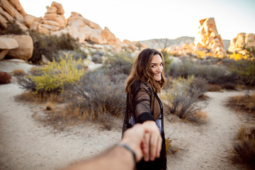USA, California, Los Angeles, portrait of smiling woman walking hand in hand in Joshua Tree National Park