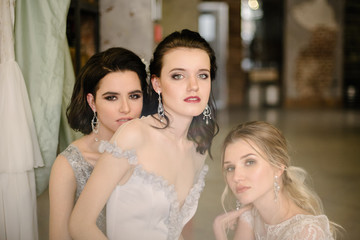 Naklejka premium Girls in white wedding dresses are posing. Advertising of wedding dresses