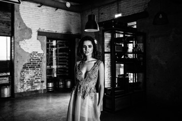 Model posing in a white long wedding dress indoors by the window. Advertising of wedding dresses