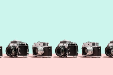 Photo cameras organized in a row over colorful background
