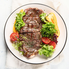 Grilled beef steak and fresh vegetables on plate