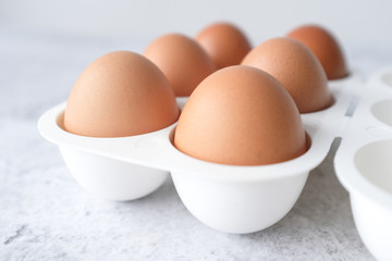 Eggs on light white and grey concrete table top with copy space on white wall blurred background. Closeup, selective focus.
