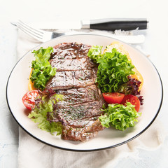 Grilled beef steak and fresh vegetables on plate