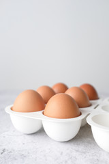 Eggs on light white and grey concrete table top with copy space on white wall blurred background. Closeup, selective focus.