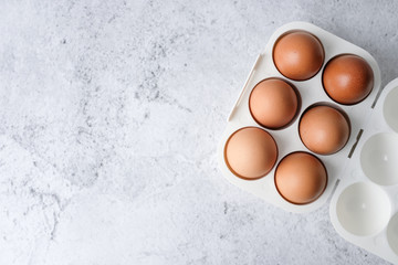 Eggs on light white and grey concrete table top with copy space. Top view.