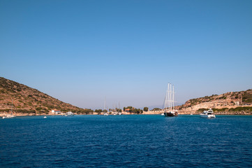 Fototapeta premium Sailing boat anchored in the harbor on the azure sea