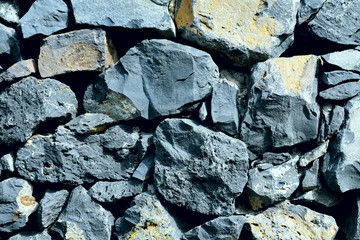 Background texture of natural gray stone of different sizes. Cropped shot, horizontal, close-up, nobody, top view. Concept of construction and nature.