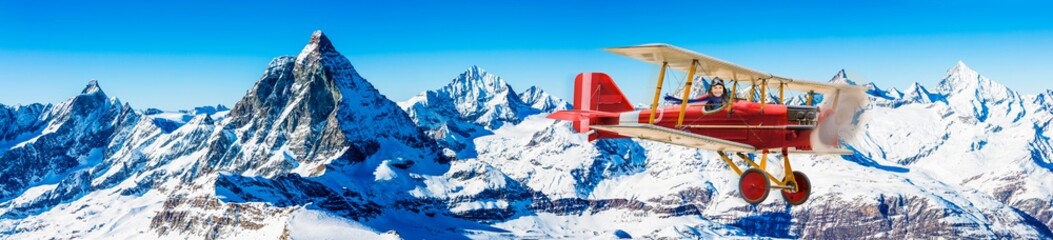 Child girl pilot aviator in airplane flying over winter mountains. The travel for ski by air...