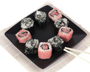 Sushi Set - different types of Maki sushi and chopsticks on a b