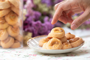 Hand picking Cookies Singapore or cashew Cookies with dried vintage flower on vintage background