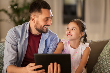 family, fatherhood and technology concept - happy father and little daughter with tablet pc...