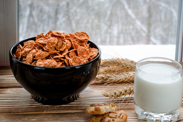 A healthy breakfast. Cereals are at the black plate on the wood background