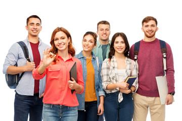 education, high school and people concept - group of smiling students with books showing ok hand sign over white background