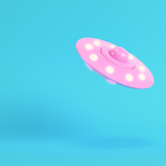 Pink ufo or alien spaceship on bright blue background in pastel colors