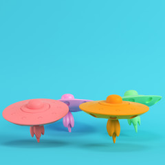 Four colorful ufos or alien spaceships on bright blue background in pastel colors.