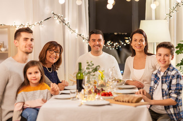celebration, holidays and people concept - happy family having dinner party at home