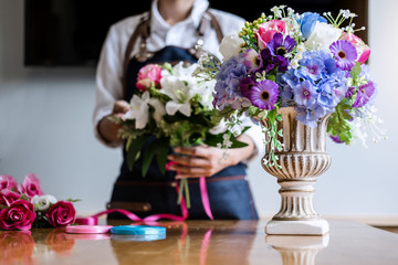 Arranging artificial flowers vest decoration at home, Young woman florist work making organizing diy artificial flower, craft and hand made concept