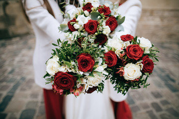 red wedding bouquet in brides hands