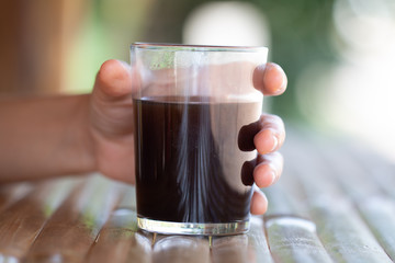 Girl holding cup of coffee in morning on Thailand coffee shop's style