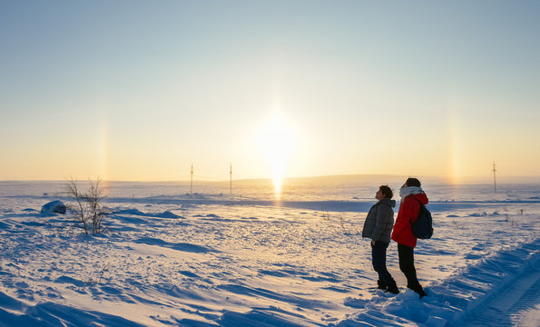 Asian couple looking at rainbow and sun in Arctic at Teriberka, Russia
