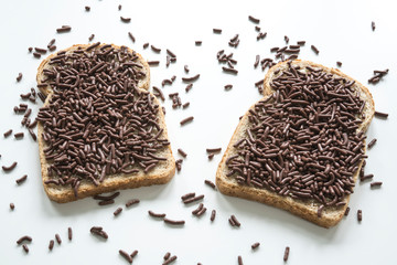 two slices of bread with typical dutch chocolate hail, hagelslag . Against white background