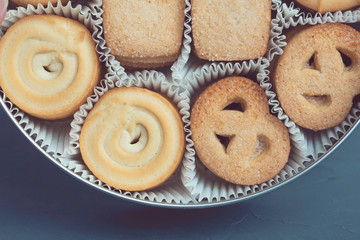 Cookies in a metal tin on a dark blue background. Close-up. Macro.