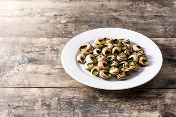 Escargots de Bourgogne. Snails with herbs and garlic butter on a plate. Copyspace