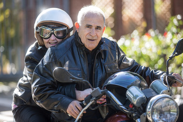 Fototapeta premium Coppia di anziani vanno in giro sulla loro Motocicletta d'epoca
