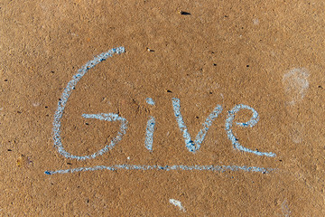 Fototapeta premium the word Give written with sidewalk chalk on gray concrete pavement background