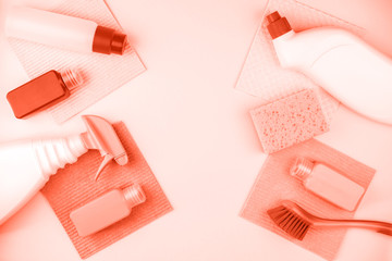 House cleaning products are on coral background.