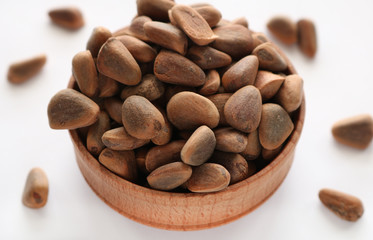 Pine nuts poured into a round plate. Pine nuts contain many vitamins minerals and omega-3.