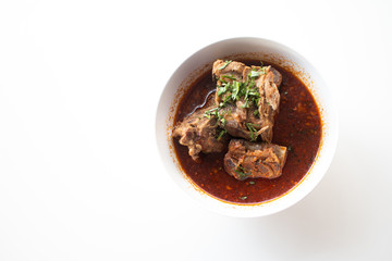 Pork bone in spicy soup served on white table in canteen