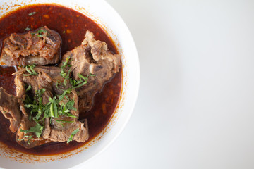 Pork bone in spicy soup served on white table in canteen