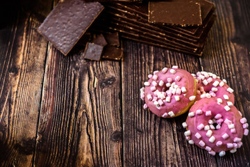 Donuts with pink sugar and chocolate tablets for breakfast on vacation.