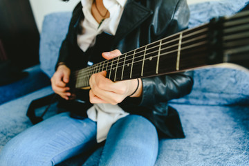 Detail of the fingers of a guitarist placed on the fret of the mast of the guitar playing a chord doing Tapping.