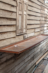 The counter on wall with closed window of wooden house, street restaurant, Thailand.