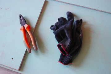 pliers and gloves on the background of drywall. repair of the apartment and house, construction....
