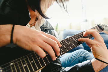 Placing the fingers on a guitar to play some notes by a professional guitarist.