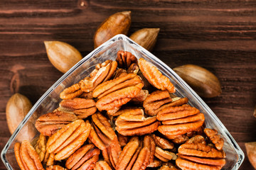Pecan nuts in the shell with pecan kernel on wooden background