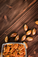 Pecan nuts in the shell with pecan kernel on wooden background
