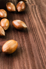 Pecan nuts in the shell on wooden background