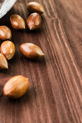Pecan nuts in the shell on wooden background