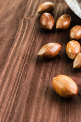 Pecan nuts in the shell on wooden background