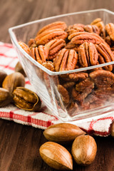 Pecan nuts in the shell with pecan kernel on wooden background